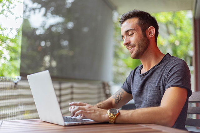 A man is working on laptop at a table