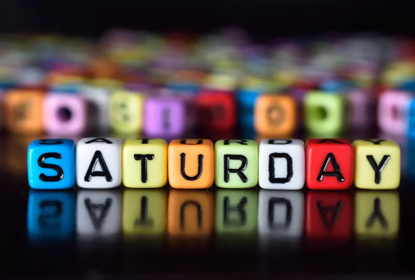 Saturday is written on colorful blocks on a black surface